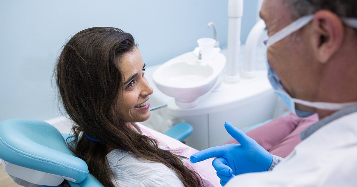Una paciente conversa con su dentista durante la consulta